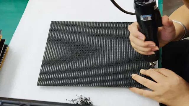 Workers assembling LED display modules at WINFIN factory