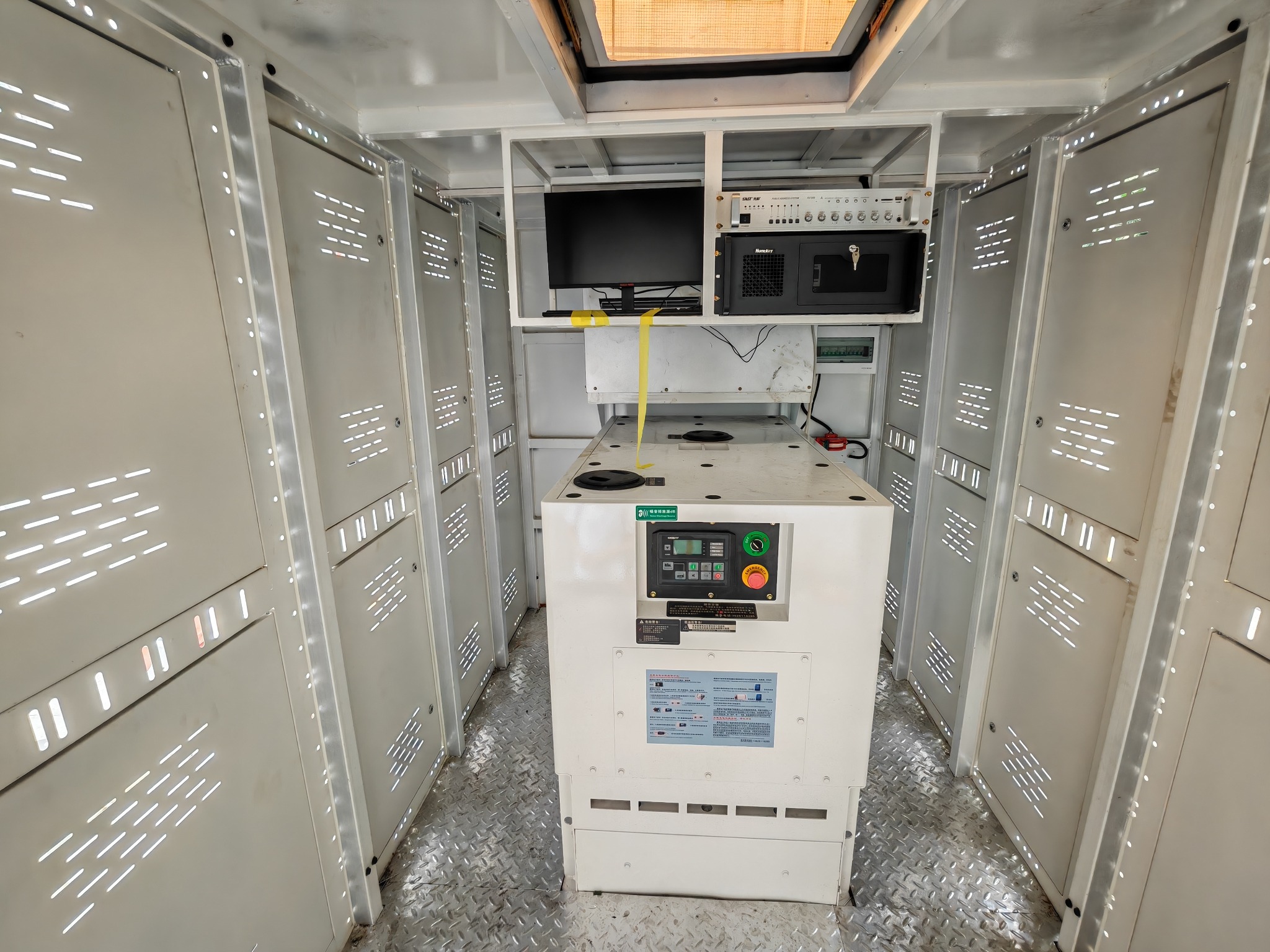 Interior of a mobile LED advertising truck showing the control station, equipment racks and generator