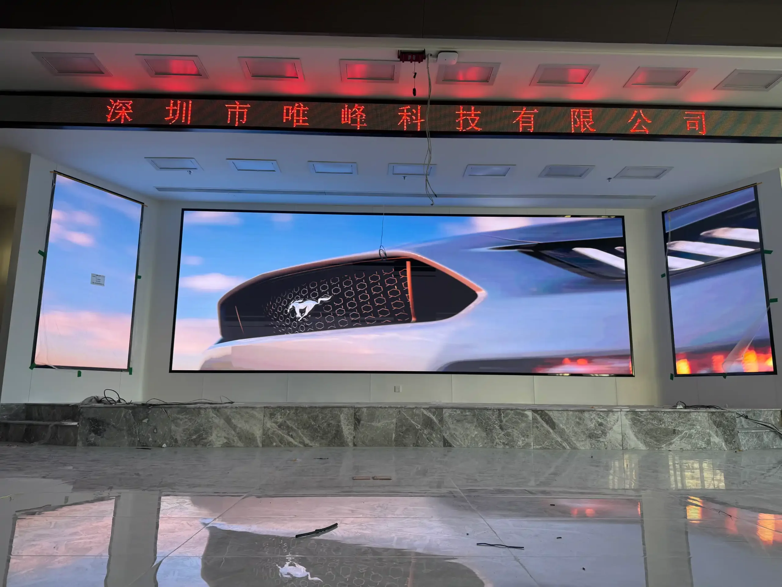 P1.25 indoor LED display with a wide central screen and two vertical side screens in a university performance hall in Zhanjiang, China